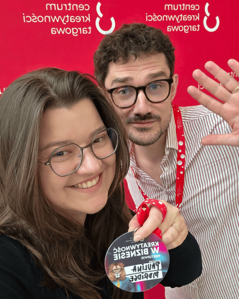 Zdjęcie pracowników mbridge na ściance zdjęciowej centrum kreatywności targowa z meet up-u kreatywność w biznesie.